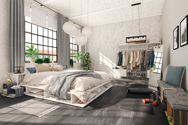 Ljust sovrum i loftstil med säng, klädställning och sportutrustning