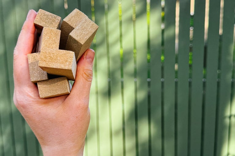 Hand håller träklossar