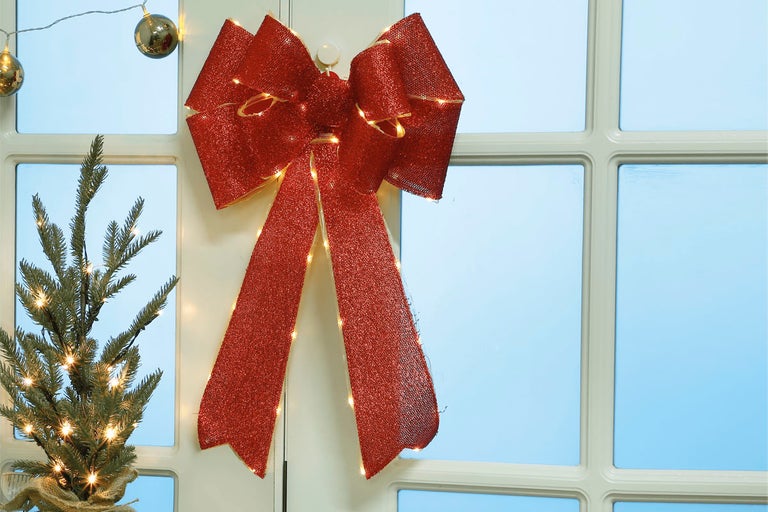 Dekorativ rosett med ljusslinga för juldekoration på fönstret