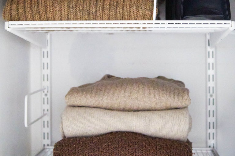 Garderob med tröjor på hyllor