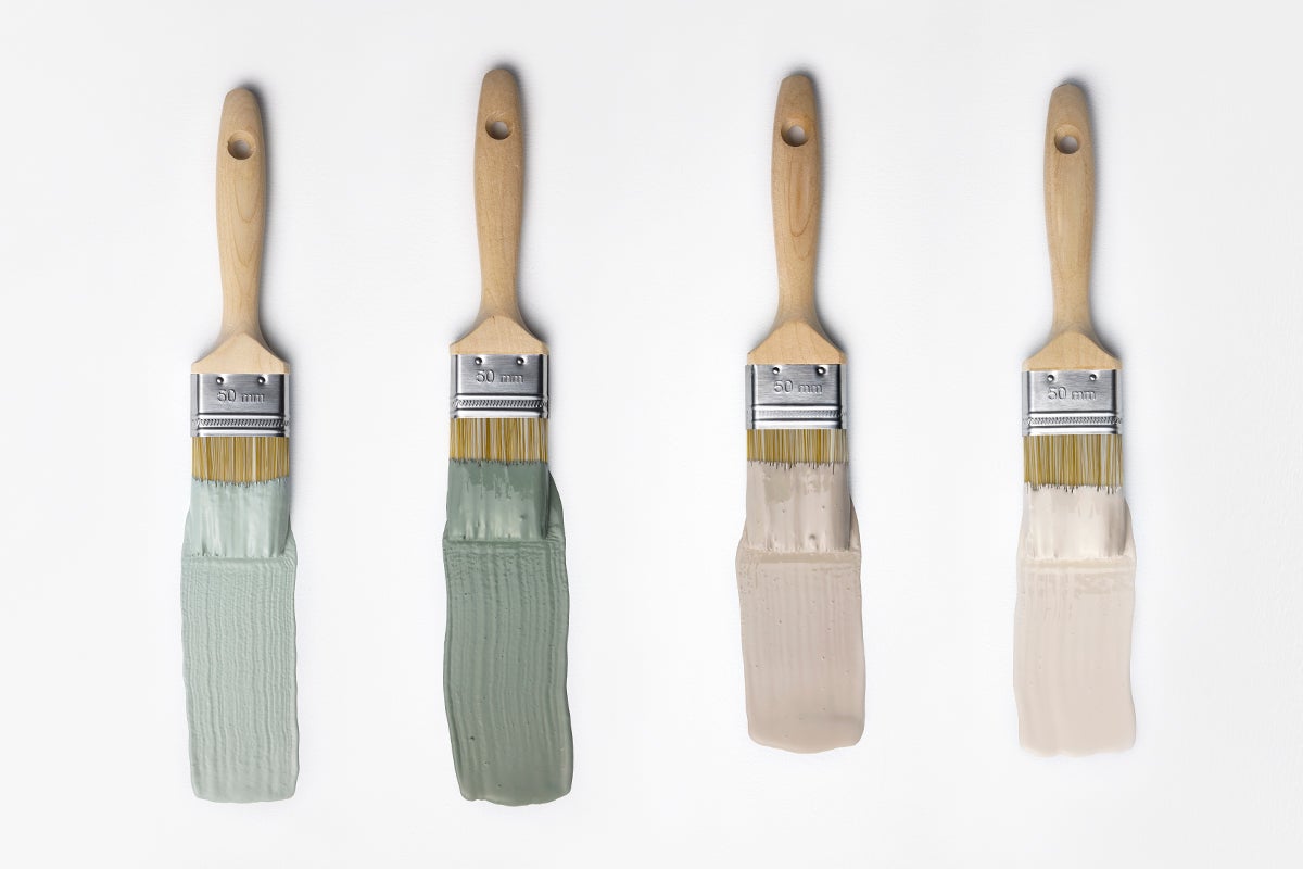 Fyra flatpenslar med 50 millimeters bredd och träskaft, var och en med olika färgprover i gröna och beigea toner.