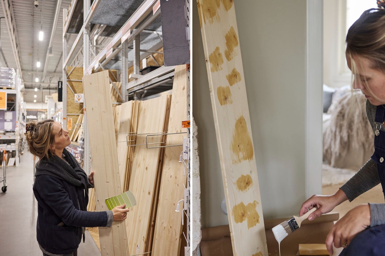 En kvinna väljer en träplanka i ett byggvaruhus och grundmålar kvistar på en planka med vit färg.