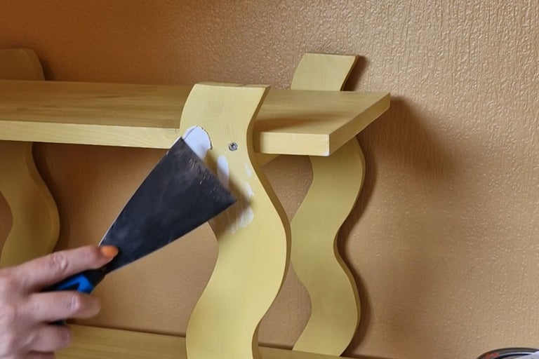 Hyllreparation med spackel och spackelspade