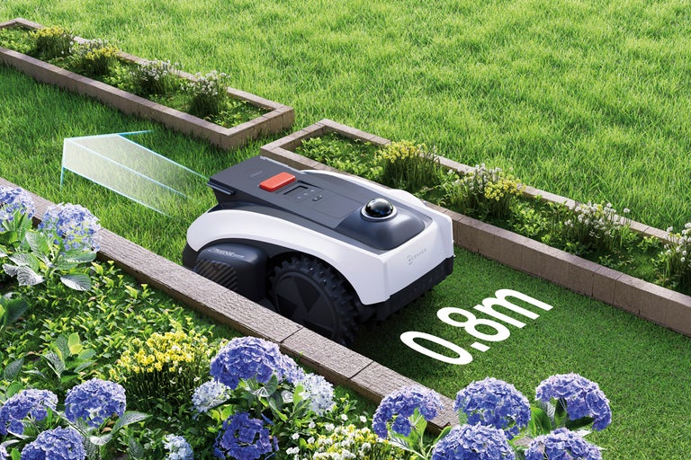Ecovacs robotgräsklippare navigerar genom en smal passage på 0,8 meter i trädgården mellan blombänkar.