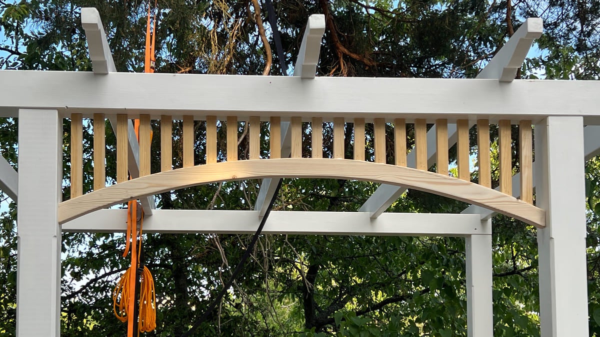 Detaljvy av ett lusthus med träbjälkar och staket