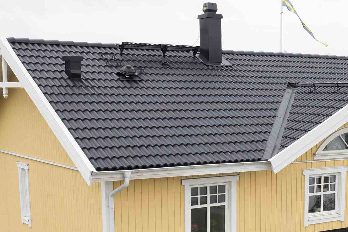 Tak med takpannor, skorsten och takränna på ett hus
