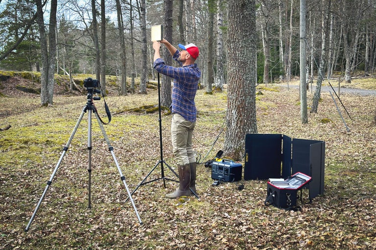 Utomhusfotografering med kamera på stativ, ljus och generator