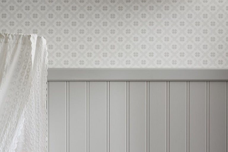 Väggdekoration med blommig tapet, paneler och gardin