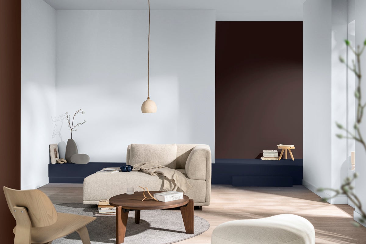 Vardagsrum med soffa, bord och dekorativa element i en ljus och vänlig design.