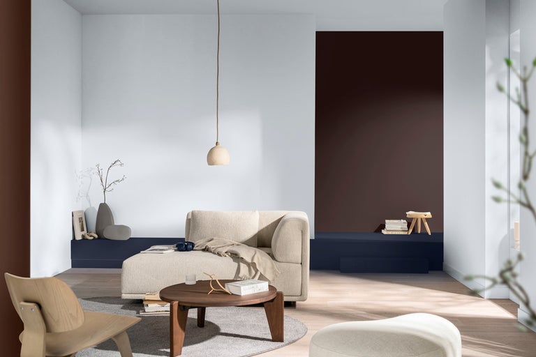 Vardagsrum med soffa, bord och dekorativa element i en ljus och vänlig design.