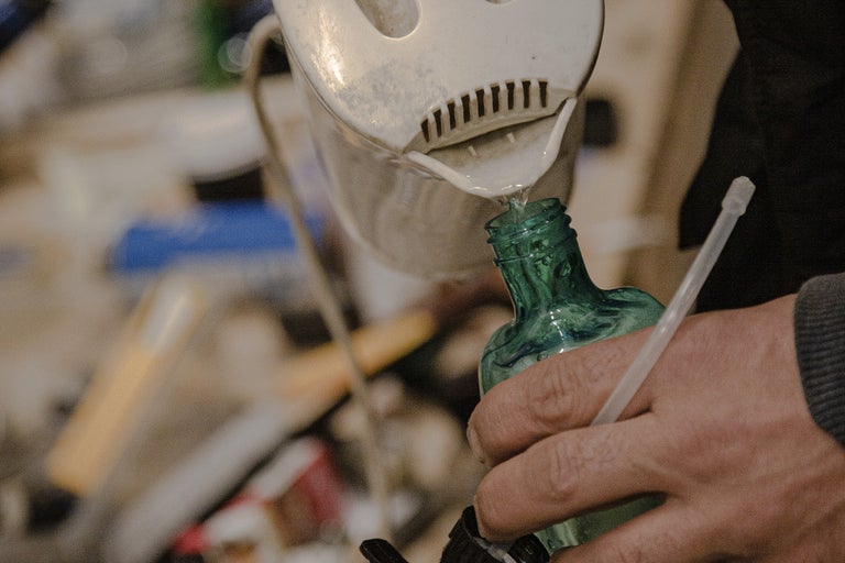 Vatten hälls från en vattenkokare i en flaska.