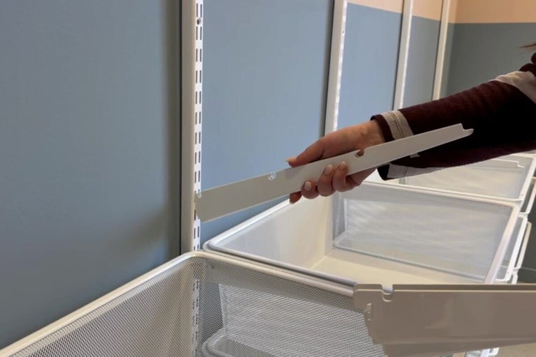 Detaljvy av en hyllkonstruktion med en person som fäster ett fäste