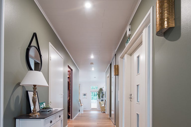Hall med byrå, spegel, lampa och dörrar