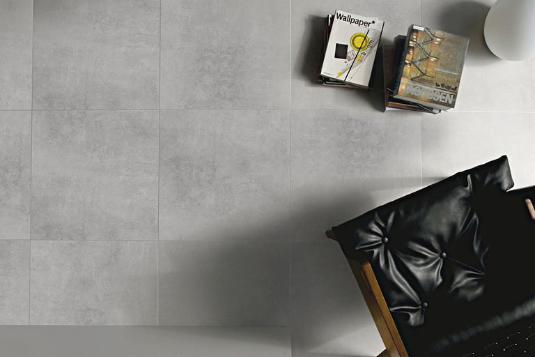 Grå golvplattor med böcker och en fåtölj