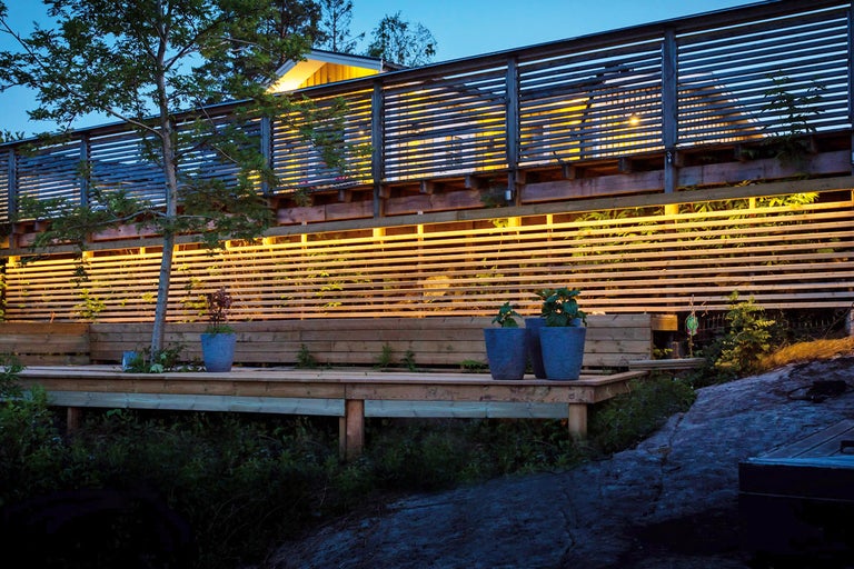 Träterrass med horisontell träpanel och växter i krukor