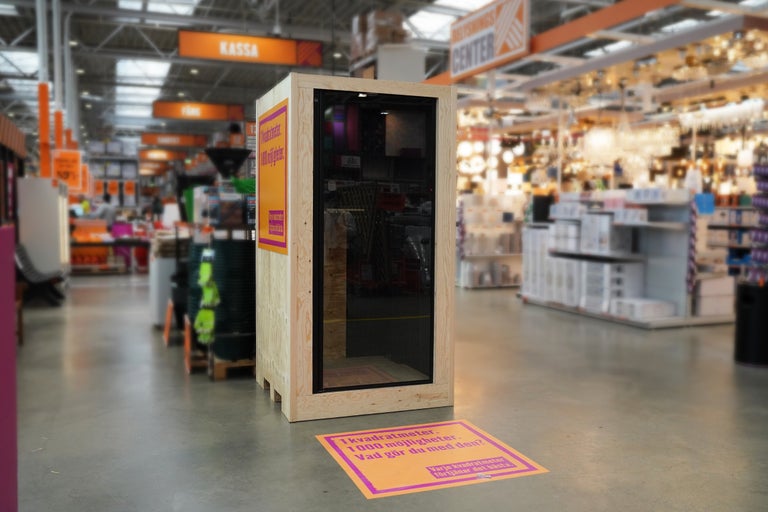 Hytt av trä med glasdörr i en byggvaruhus.