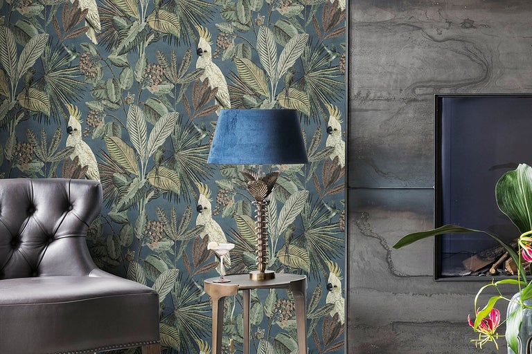 Vardagsrum med djungeltapet med papegojor och växtmotiv, fåtölj och golvlampa