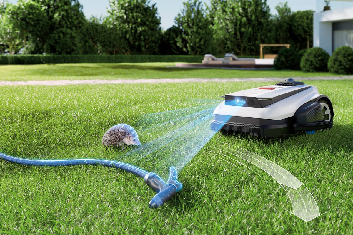 Robotgräsklippare med hinderdetektering känner igen en igelkott och en trädgårdsslang på en gräsmatta.