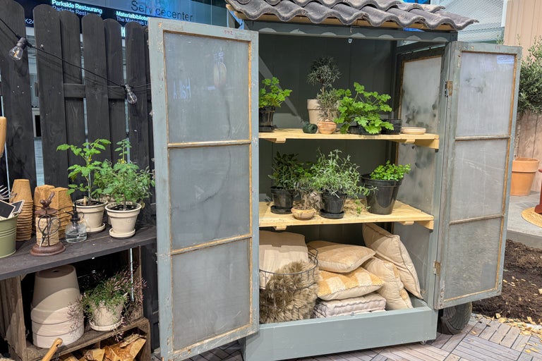 Flyttbar hylla med växter, örter och kuddar på tre hyllor