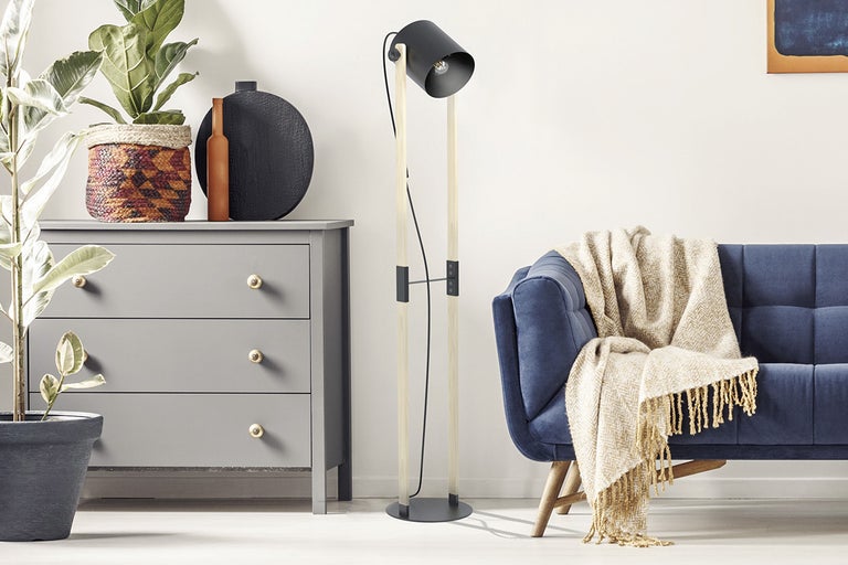 Vardagsrumsscen med byrå, golvlampa och soffa