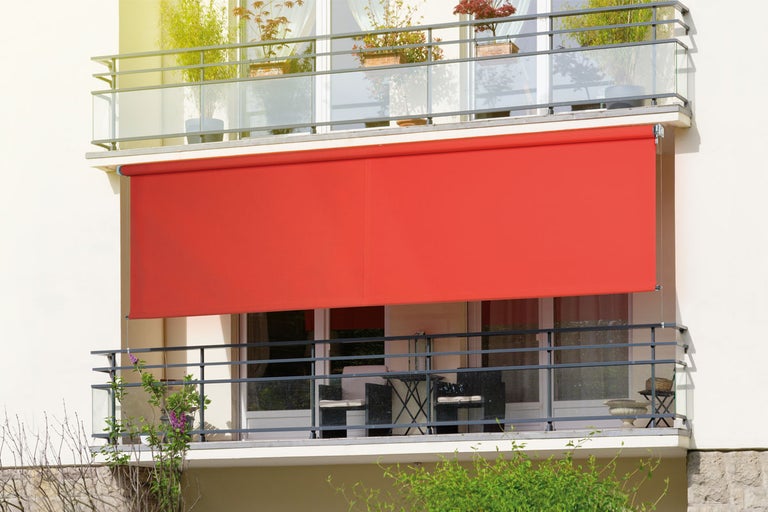Röd balkongmarkis på en byggnad med balkonger.