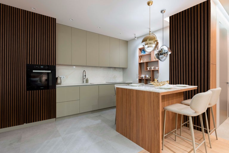 Ljust kök med pentry, köksö, diskho, spis och fläkt