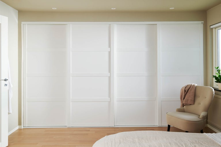 Sovrum med vit skjutdörrsgarderob