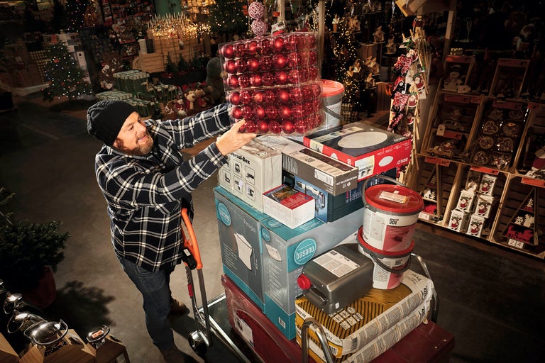 En man med en skottkärra full av julinköp på Hornbachs byggmarknad.