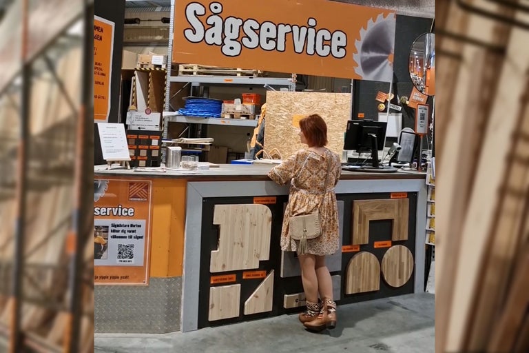 Kund vid sågservice disken i Hornbachs byggvaruhus med träprover