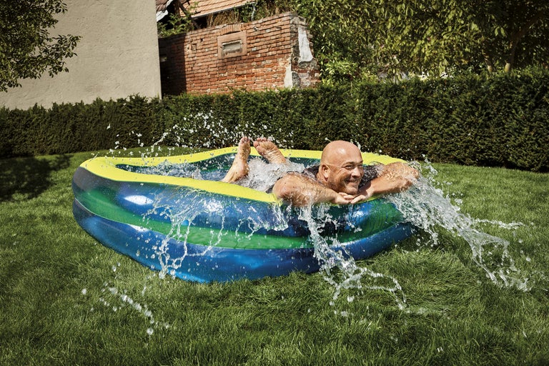 Man kopplar av i en uppblåsbar pool i trädgården.