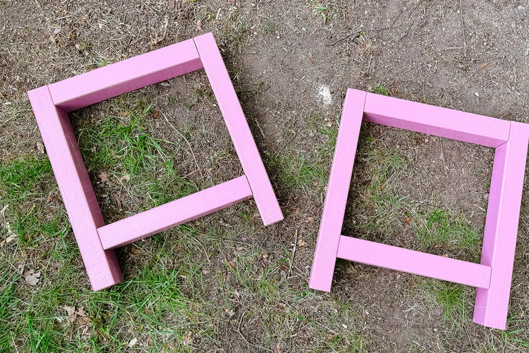 Två rosa träbockar för byggnadsarbeten utomhus