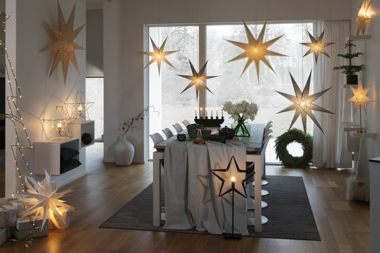 Festligt inredd matplats med stjärnlampor, bord och juldekorationer för en mysig atmosfär.