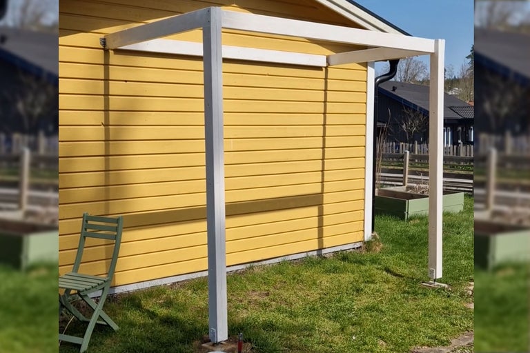 Träterrassmarkis på gult hus
