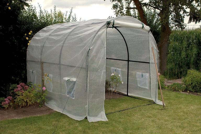 Växthus av plast i trädgården