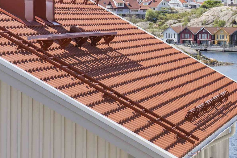 Tak med röda takpannor och monterad takstegsanläggning