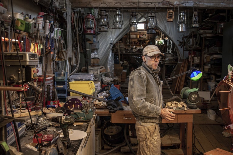 Verkstad med verktyg, arbetsbänk och en person