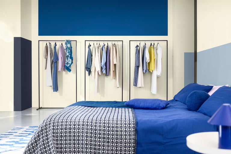 Sovrum med säng, klädställning och färgglad väggdesign