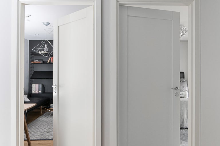 Två innerdörrar i olika nyanser öppnar utsikten mot vardagsrummet och sovrummet