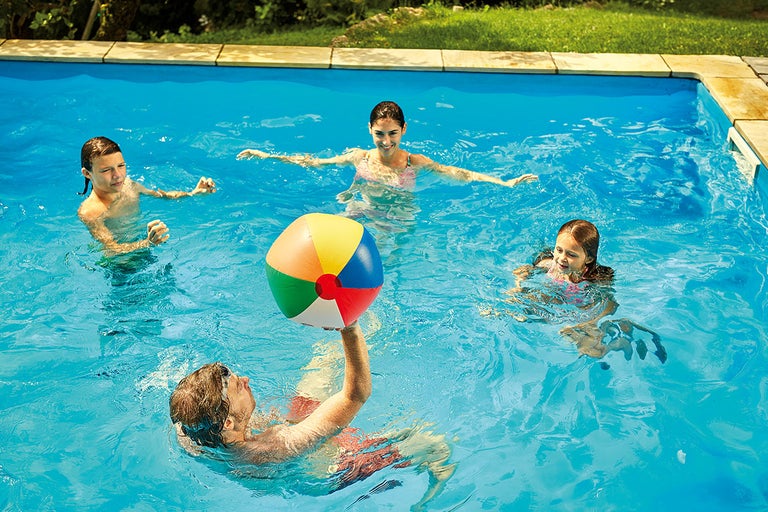 Barn leker med en boll i poolen.