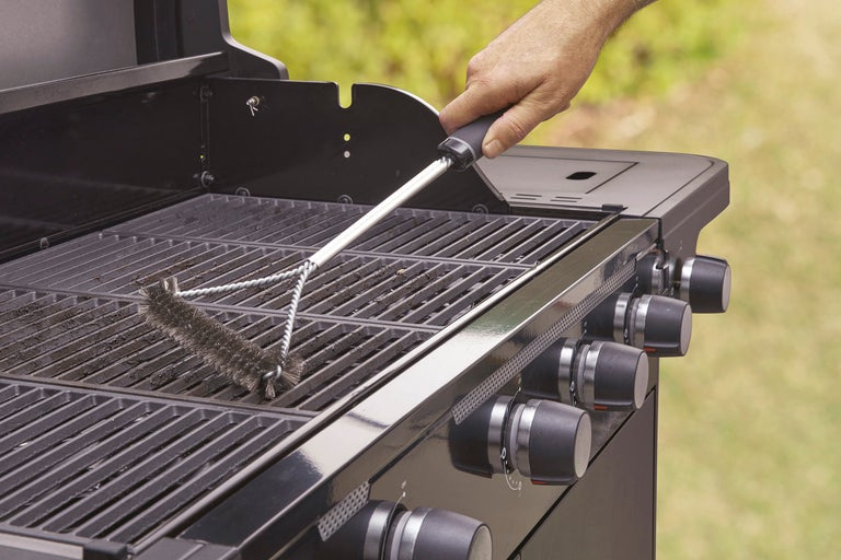 En grillborste rengör ett grillgaller.