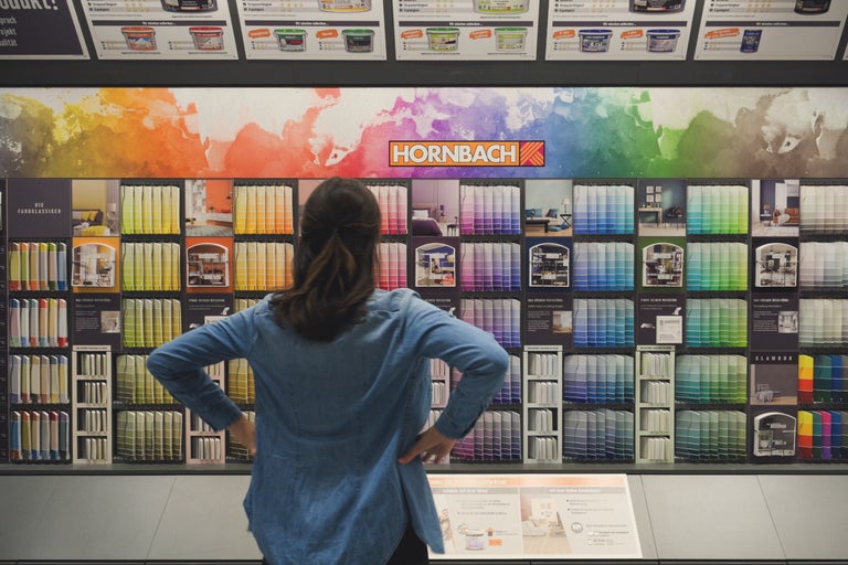 En kund tittar på färgsortimentet på Hornbach.