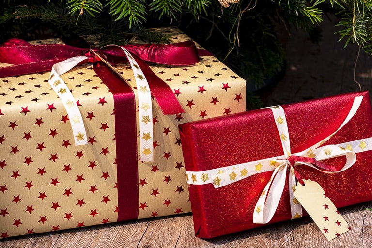 Två julklappar med band under en julgran