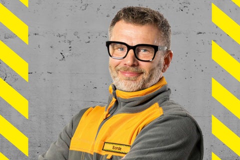 Porträtt av en man med glasögon och arbetsjacka