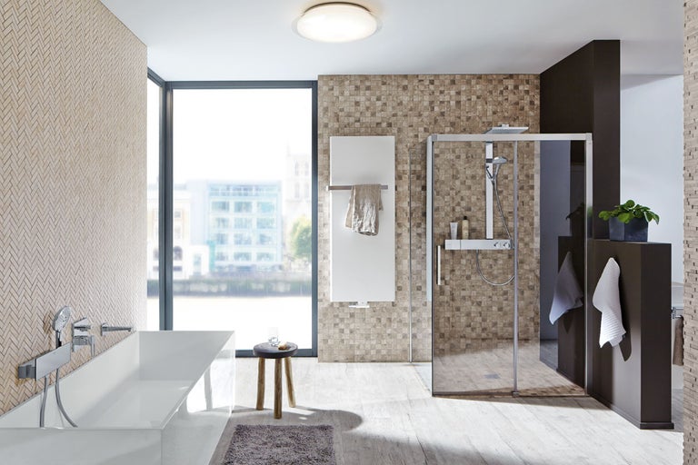 Modernt badrum med badkar, dusch, radiator och mosaikplattor