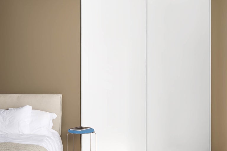 Sovrum med skjutdörrsgarderob och säng