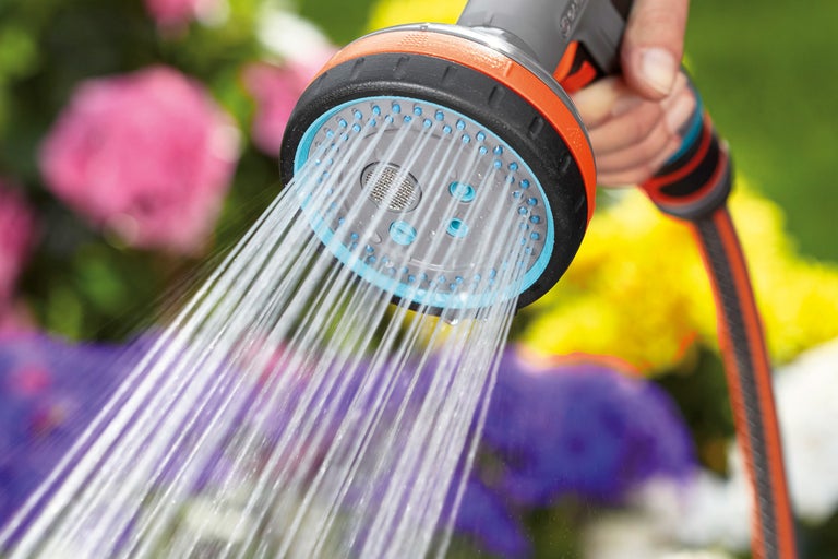 Trädgårdsslang med spruthuvud som används för att vattna blommor