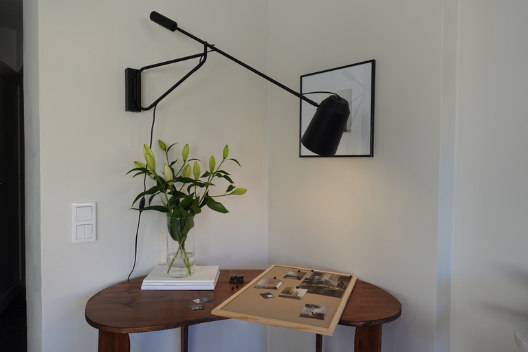 Dekorativ interiör med bord, vägglampa och blomvas