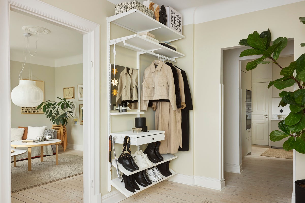 Hall med vitt förvaringssystem, kläder och skor