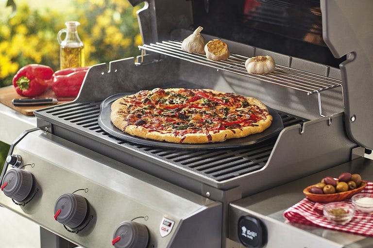 Gasolgrill med pizza, vitlök, paprika, olivolja, oliver och kryddor