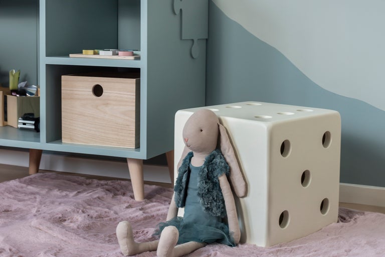 Barnscen med hylla, trälåda, kubformad pall och gosedjur på en matta